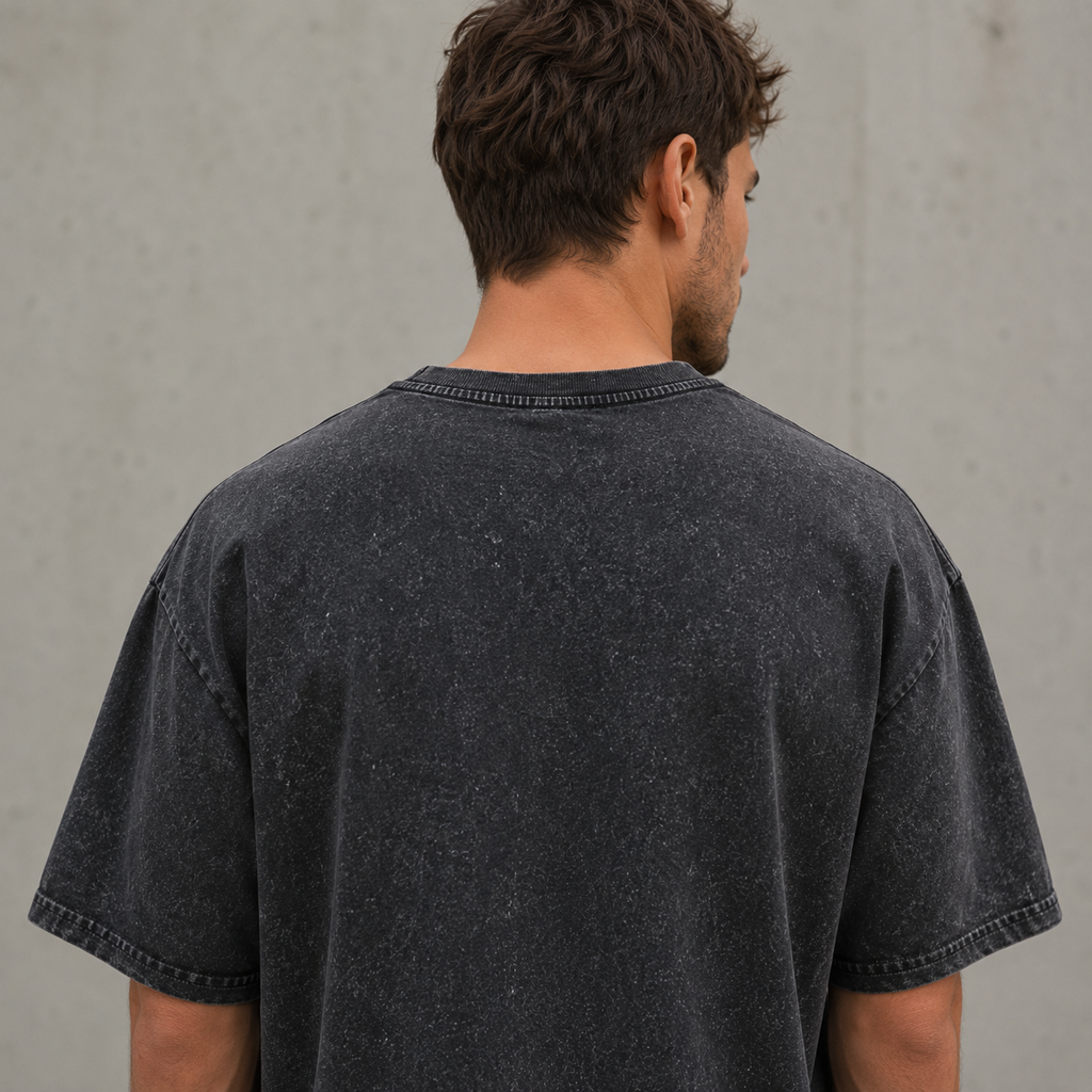 Detailansicht der hochwertigen Verarbeitung und Doppelabsteppung am Saum des grauschwarzen Oversize Shirts.