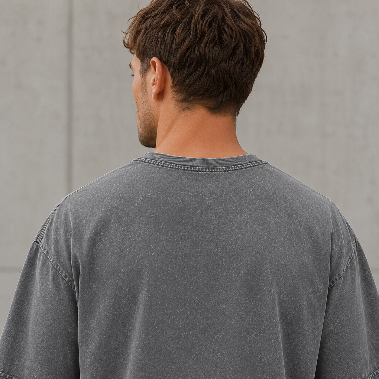Detailansicht der hochwertigen Verarbeitung und Doppelabsteppung am Saum des grauen Oversize Shirts.