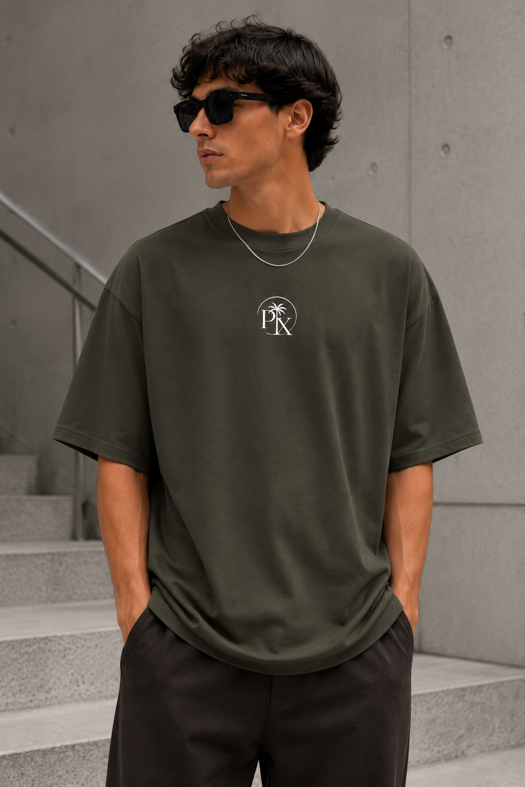 Nahaufnahme des minimalistischen Palmex-PX-Logos auf der Brust des grünen Shirts.